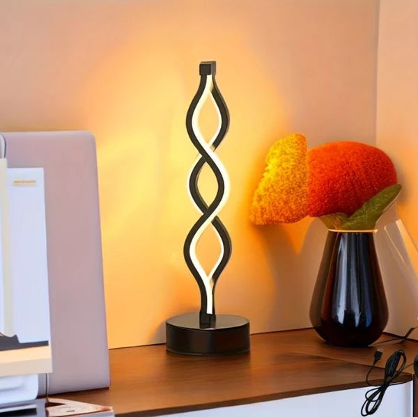 Black spiral LED table lamp on a desk
