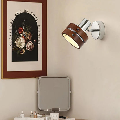 Adjustable wall spotlight in chrome and brown on a bedroom wall