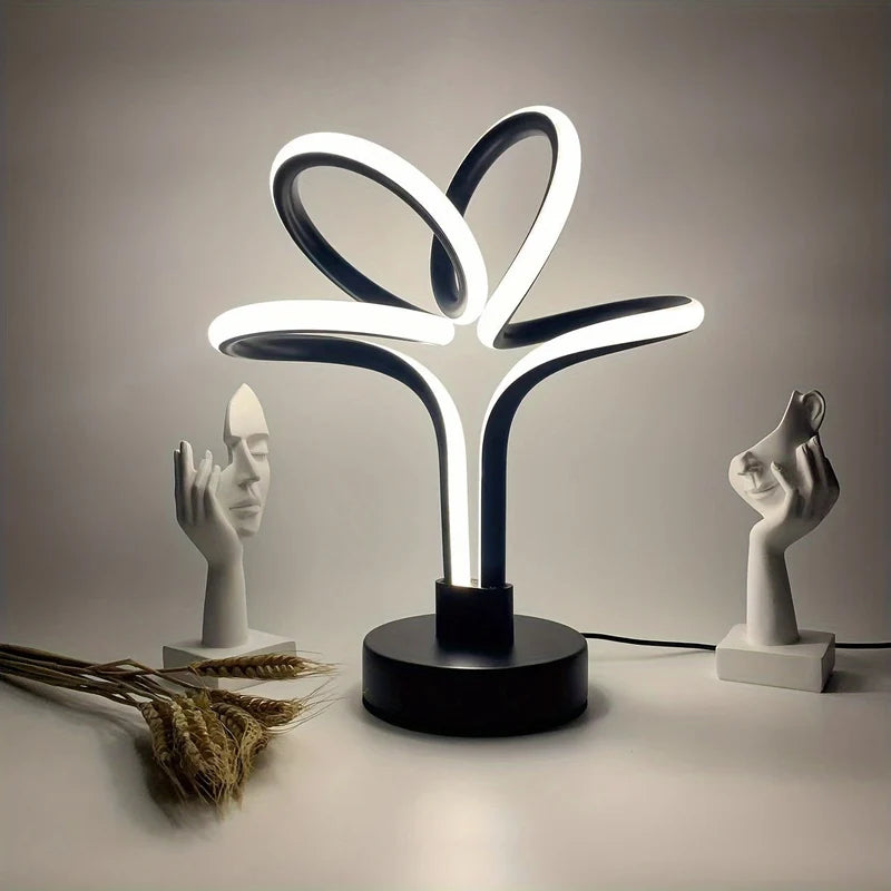 Black LED loop table lamp glowing on a shelf