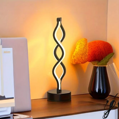 Black spiral LED table lamp on a desk
