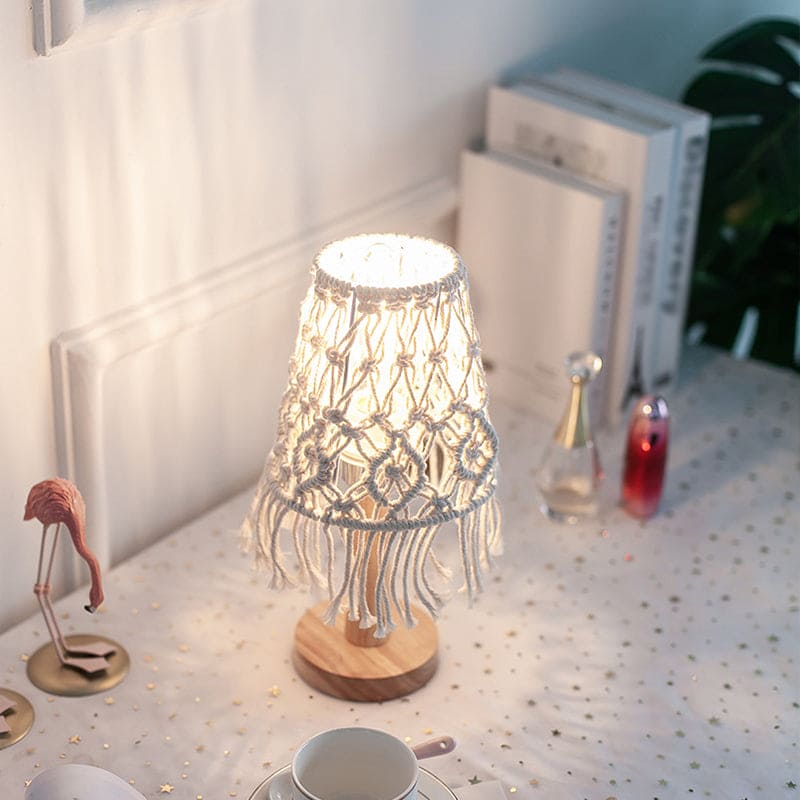 Boho macramé table lamp glowing beside books