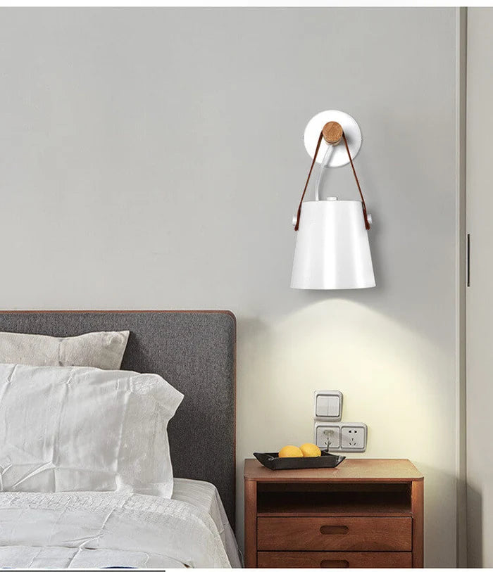 Scandinavian wall lamp with wooden arm above a bedside table